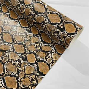 Peut inclure: Rouleau de tissu vinyle à motif peau de serpent brun et noir.