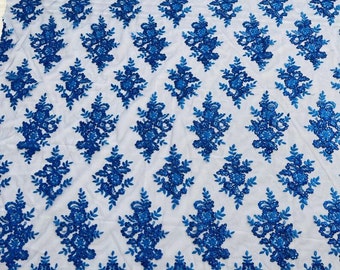 Puede incluir: Tela de encaje floral azul real con un patrón delicado. El encaje tiene un borde festoneado y es perfecto para agregar un toque de elegancia a cualquier proyecto.