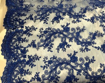 Puede incluir: Tela de encaje bordada azul real con un patrón floral. El encaje tiene un diseño delicado e intrincado con pequeñas cuentas en todo.