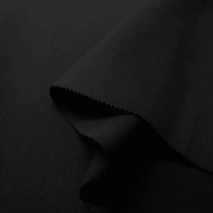 Pode incluir: Tecido preto dobrado em forma triangular. O tecido é liso e tem um leve brilho.