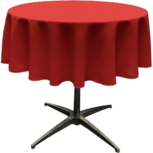 May include: A red round tablecloth with a black metal base. The tablecloth is draped over a round table with a star-shaped base.