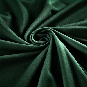 Op de afbeelding: Een close-up van een diep groene stof met een gladde, zijdeachtige textuur. De stof is gevouwen en gedrapeerd, waardoor een zacht, vloeiend effect ontstaat.