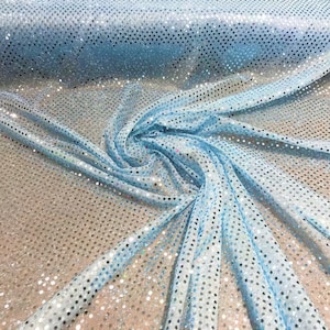 May include: Light blue iridescent fabric with small, round sequins. The fabric is folded and draped, showing the texture and sparkle of the sequins.
