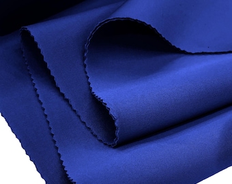 May include: A bolt of solid royal blue fabric with a smooth, matte texture. The material is folded in layers, showcasing the vibrant, deep blue color and the clean, finished edges of the textile. The fabric appears opaque and uniform.