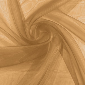 Peut inclure: Un gros plan sur un tissu transparent de couleur or, avec une texture douce et fluide. Le tissu est drapé et plié, créant un motif tourbillonnant.