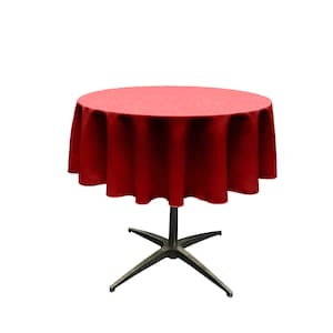 May include: A red round tablecloth draped over a table with a four-legged base.