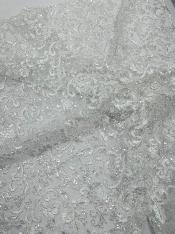 White Metallic Corded Flowers Embroider With Sequins On a Mesh Lace Fabric- Sold By The Yard.