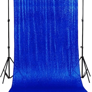 May include: A royal blue sequin backdrop for photography or events. The backdrop is made of a shimmering fabric with a subtle sheen.