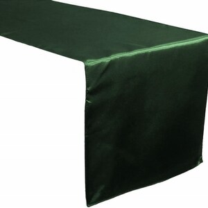 May include: A dark green satin table runner. The runner is 14 inches wide and 72 inches long.