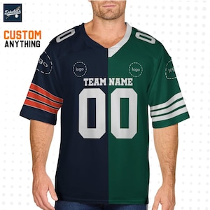 Pode incluir: Uma camisola de design dividido em azul marinho e verde. O lado azul marinho tem listras laranja na manga, o lado verde tem listras brancas. A camisola apresenta o texto "TEAM NAME" e o número "00" em branco. As palavras "CUSTOM ANYTHING" também são visíveis.