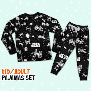 Op de afbeelding: Zwarte Star Wars pyjamaset voor kinderen en volwassenen. De top met lange mouwen en de broek hebben een ruimtethema met verschillende ruimteschepen en het Star Wars-logo in het wit. De tekst "KID/ADULT PAJAMAS SET" staat in het oranje.
