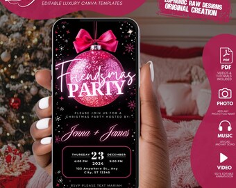May include: A smartphone screen shows a digital invitation for a "Friendsmas Party." The design features a pink bauble with the text "Friendsmas Party." Details include the date, time, location, and RSVP information. The phone is held against a blurred background.
