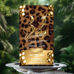May include: A birthday invitation with a leopard print background and gold accents. The invitation reads "32nd Birthday" in gold script, with event details for Jamila Love. Gold balloons frame the invitation, which is held on a silver tray.