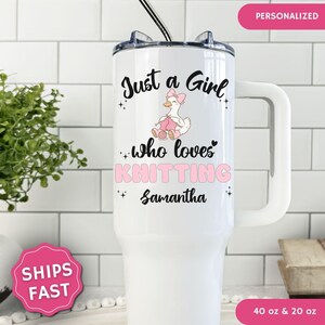 May include: A white stainless steel tumbler with a handle, featuring a graphic of a white duck wearing a pink bow and knitting with pink yarn. The text reads: Just a Girl who loves KNITTING Samantha. The tumbler is available in 40 oz and 20 oz sizes.
