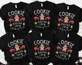 May include: Six black t-shirts with the text "COOKIE BAKING CREW" in white. Each shirt features a gingerbread man, candy canes, and Christmas lights. The bottom right corner of the image has the text "SHIRTS ONLY".