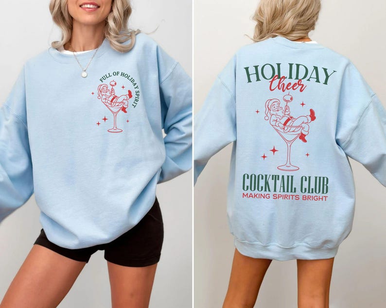 K&ouml;nnte beinhalten: Hellblaues Sweatshirt mit roter und wei&szlig;er Grafik von Santa Claus in einem Cocktailglas. Auf der Vorderseite steht "FULL OF HOLIDAY SPIRIT". Auf der R&uuml;ckseite steht "HOLIDAY CHEER COCKTAIL CLUB MAKING SPIRITS BRIGHT".
