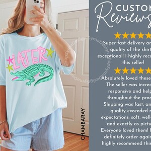 May include: Light blue t-shirt with the word "LATER" in pink and yellow stars, and a green alligator graphic. The shirt is worn with blue and white striped shorts. The image also includes customer reviews.