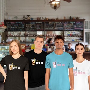 May include: Four people wearing t-shirts with a bubble tea graphic and the text "let's get BOO-BA". The shirts are black, teal, and white. The bubble tea graphic includes a cup, straw, and tapioca pearls.