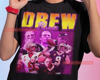 Peut inclure: T-shirt noir avec un graphique violet et jaune de Drew Brees et le texte "Drew Brees" dans un style rétro.