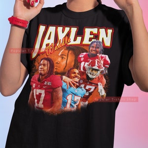 May include: Black t-shirt with a vintage-style graphic of a football player with the text "Jaylen Waddle" on the front.