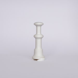 May include: White ceramic vase with a rounded top and a wide base. The vase has a smooth, matte finish.