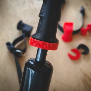 May include: A black bicycle pump with a red ring around the handle. The ring has the word "RAPID" printed on it.