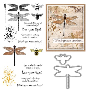 Könnte beinhalten: Eine Sammlung von Bastelmaterialien zum Thema Libellen und Bienen. Enthält Libellen- und Bienenillustrationen, eine Karte mit einem Libellen-Design und die Sätze "You make the world more colorful" und "Bee-you-tiful".