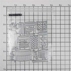 May include: A set of 14 metal die-cut shapes for crafting, including jars, boxes, bows, and stars. The shapes are in a clear plastic bag with a white grid background.