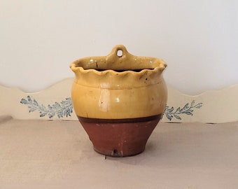 Old terracotta pot. Yellow glazed terracotta wall pot. utensil jar, country chic style.