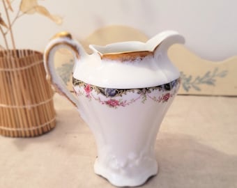Vintage milk jug with golden spout and black and pink floral frieze. Period 1918. Cream pot