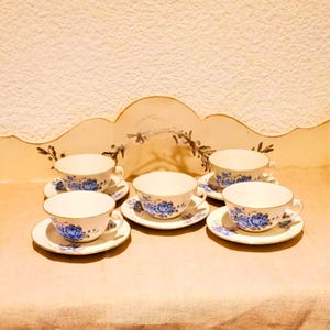 Vintage-Set aus 5 Teetassen und passenden Untertassen. Geblümte Steingutbecher in Blau- und Grautönen