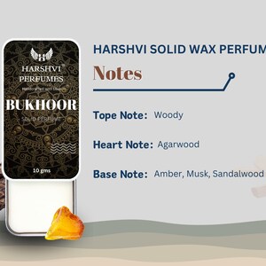 May include: A small, round, white container with a gold lid. The container is labeled "HARSHVI PERFUMES BUKHOOR SOLID PERFUME" and "10 gms". The container is sitting on a wooden surface. The text "HARSHVI SOLID WAX PERFUME" is written in black above the container. The text "Notes" is written in black below the container. The text "Tope Note: Woody" is written in black below the text "Notes". The text "Heart Note: Agarwood" is written in black below the text "Tope Note: Woody". The text "Base Note: Amber, Musk, Sandalwood" is written in black below the text "Heart Note: Agarwood".
