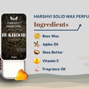 May include: A small, round, white container with a black and gold label that reads "HARSHVI PERFUMES" and "BUKHOOR SOLID PERFUME". The container is labeled with the ingredients: Bees Wax, Jojoba Oil, Shea Butter, Vitamin E, and Fragrance Oil.