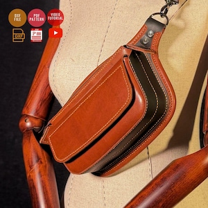 Op de afbeelding: Bruine leren crossbodytas met klepsluiting en een zwarte accentstreep. De tas wordt op een mannequin getoond en heeft een zilverkleurige kettingriem. De tas heeft een rechthoekige vorm en is gemaakt van gestikt leer.