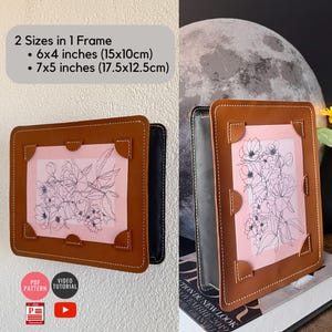 以下が含まれることがあります： ピンクの背景に白黒の線画の花が描かれた、茶色の革製のフォトフレームが2つ。フレームは、15x10cmと17.5x12.5cmの2種類のサイズの写真を収納できるように設計されています。