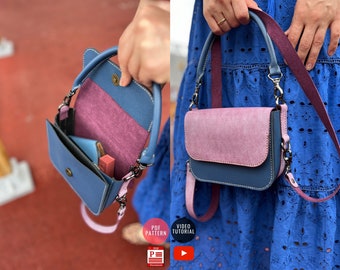 May include: A blue and pink leather handbag with a top handle and a long strap. The bag has a flap closure and a small pocket on the front. The bag is open and you can see the inside lining.
