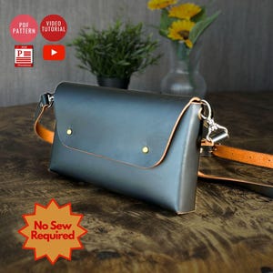 Könnte beinhalten: Eine dunkelgraue Leder-Umhängetasche mit Klappenverschluss, gesichert durch zwei goldene Nieten. Die Tasche hat einen verstellbaren, hellbraunen Riemen und silberne Beschläge. Der Text "No Sew Required" ist in einem Stern.