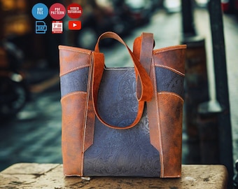 May include: A brown and blue leather tote bag with a paisley pattern. The bag has a rectangular shape with a handle and is made of different shades of brown and blue leather. The bag is sitting on a wooden surface.
