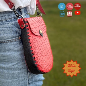 May include: A red and black crossbody bag featuring a crocodile-embossed texture on the red flap and a floral-embossed pattern on the black side panel. The bag includes a gold-tone snap closure, metal hardware, and a matching red shoulder strap.