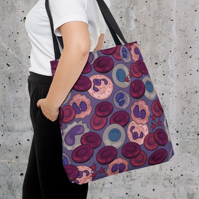 May include: A purple tote bag featuring a colourful pattern of red, pink and blue cells. The bag has a black handle and is made from a durable fabric.