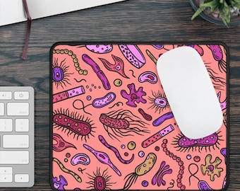 May include: A pink mouse pad with a repeating pattern of colorful bacteria and microbes. The mouse pad has a black border.