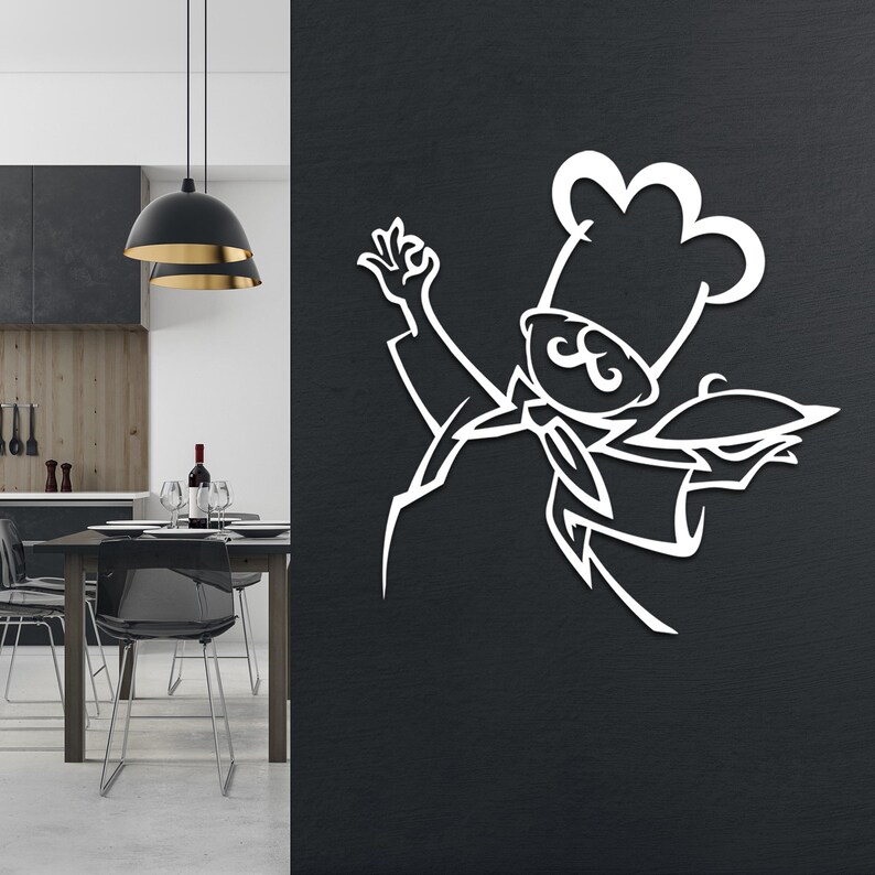May include: A white metal wall art piece featuring a stylized chef silhouette with a tall hat, a mustache, a neckerchief, and one hand raised in a gesture while the other holds a serving platter, mounted on a dark textured wall surface.