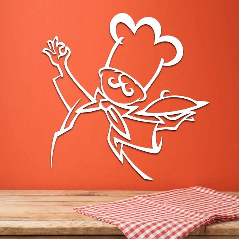 May include: A white wall decal featuring a stylized line art illustration of a chef wearing a tall toque hat and a neckerchief. The chef is depicted with one hand raised in a gesture and the other hand holding a covered serving platter.