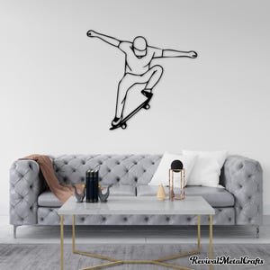 May include: Black metal wall art sculpture of a person skateboarding. The sculpture is mounted on a white wall above a gray tufted sofa with pillows and a coffee table.