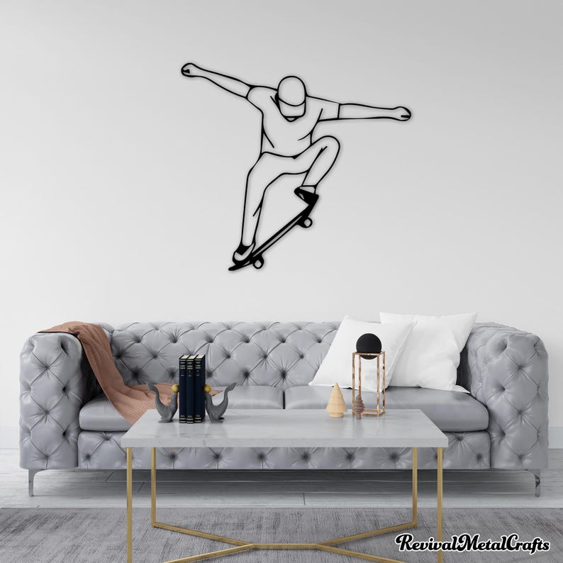 May include: Black metal wall art sculpture of a person skateboarding. The sculpture is mounted on a white wall above a gray tufted sofa with pillows and a coffee table.
