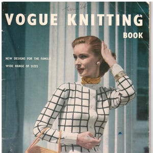 May include: A vintage Vogue Knitting Book magazine cover featuring a person wearing a white button-down cardigan with a black grid pattern, a yellow neck scarf, and a dark skirt. The person carries a yellow woven basket bag with two handles.