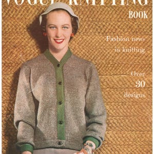 May include: A vintage Vogue Knitting Book magazine cover featuring a person wearing a grey knit cardigan with a green button placket and cuffs, a grey hat, and white gloves. The text reads Vogue Knitting Book, Fashion news in knitting, Over 30 designs.