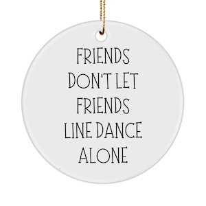 May include: White ceramic Christmas ornament with black text that reads "Friends don't let friends line dance alone".