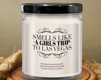 May include: A white candle in a glass jar with a black lid. The label reads "Smells Like A Girls Trip To Las Vegas". Hand poured vanilla scented candle. Goes well with bubbles and high heels. Burn time 44-50 hours. Just like us.