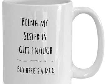 May include: White ceramic mug with black text that reads "Being my sister is gift enough but here's a mug".